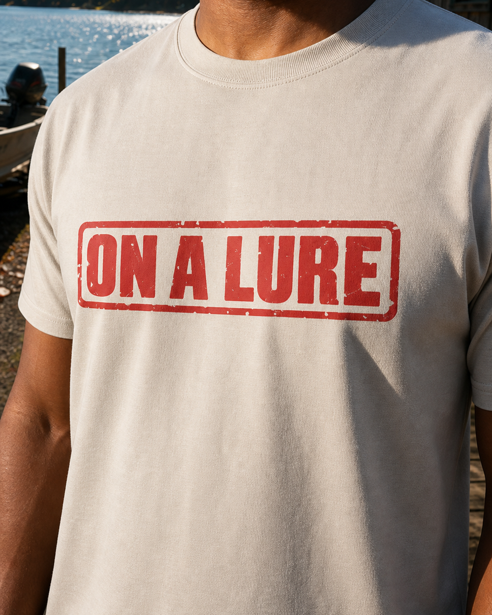 On A Lure tee — sand, worn, side