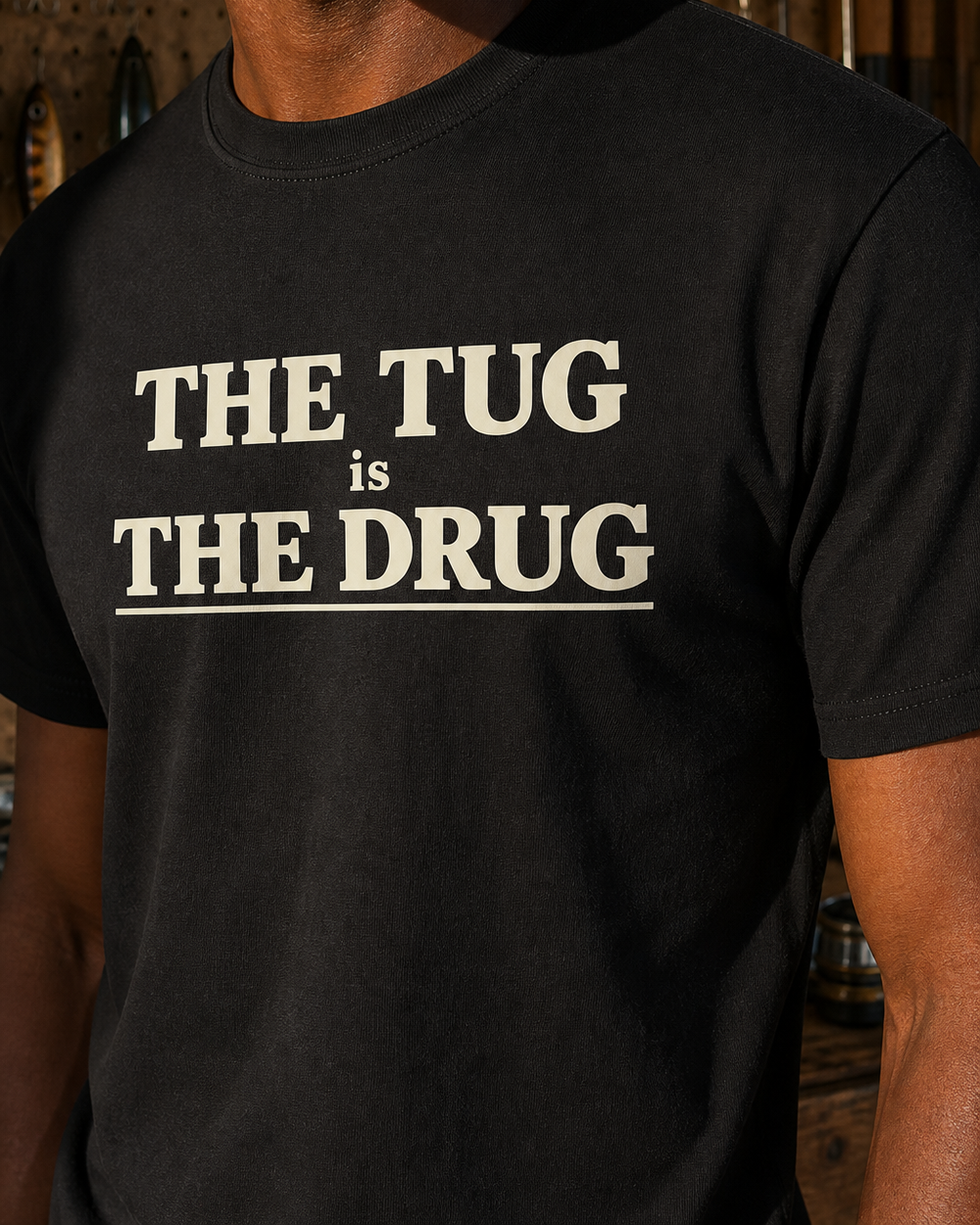 The Tug Is The Drug Stacked tee — black, worn, side